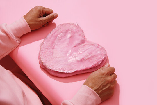 man in pink with a pink heart-shaped pastry