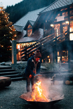 A man getting warm on a bonfire