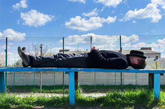 A man is sleeping on the bench