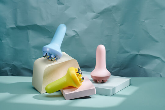 Three massagers on a blue pastel background
