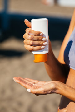 Woman at Beach Applying Sunscreen 
