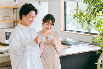 家でコーヒーを飲みながらくつろぐ男女・カップル・夫婦・恋人
