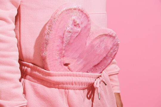 man in pink with a pink heart-shaped pastry in his sweatpants