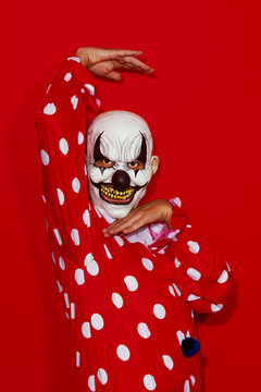 clown posing in a red costume patterned with white dots