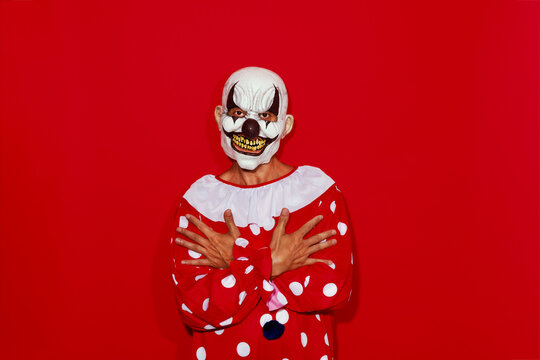 clown poses in front of a red background