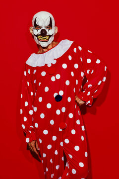 clown poses wearing a red costume with white dots