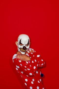 clown poses wearing a red costume patterned with white dots