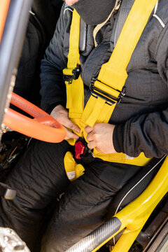 Rally driver fastening seat belt.