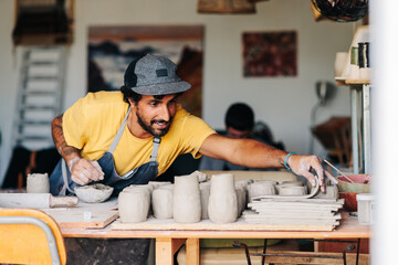 Potter working in his ceramic studio making clay pieces