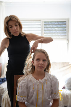 Mother combing daughter hair 