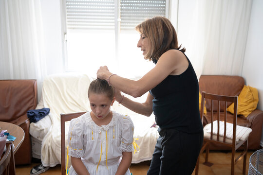 Mother combing daughter hair 