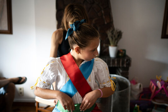 Unrecognizable woman dressing young  daughter