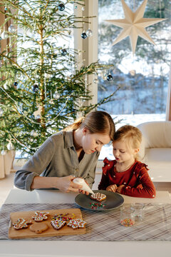 Mother and daughter decorating cookies during Christmas advent
