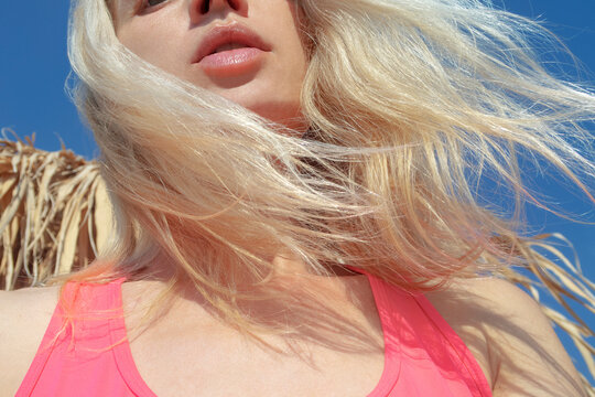 Natural lips and blond hair in the wind and blue sky