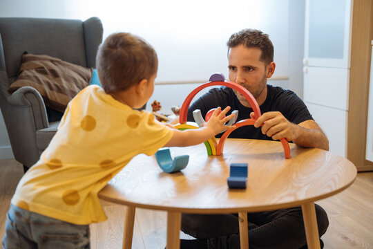 Boy playing with father in cozy room