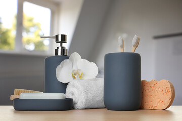 Bath accessories. Different personal care products and flower on wooden table in bathroom