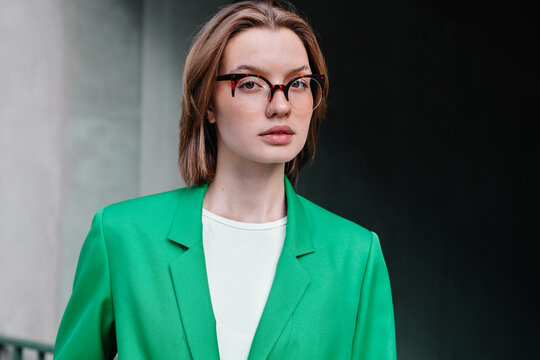 Young woman in glasses looking at camera outdoor
