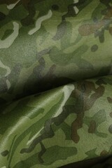 Texture of crumpled camouflage fabric as background, top view