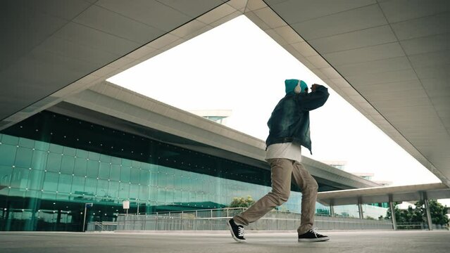 Panorama shot of happy hipster dance together while listen music from headphone at mall. Professional break dancer enjoy perform b boy footstep. Outdoor sport 2024. Modern street dancing. Sprightly.