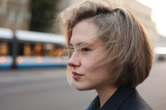 Melancholic blond model looking ahead on the street, city scenario