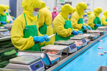 The workers trim chicken parts for special orders.