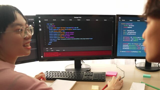 Slow motion back end software developer engineer for computer programming working together on debugging writing computing code, solving complex algorithms display on monitor in office. Burgeoning