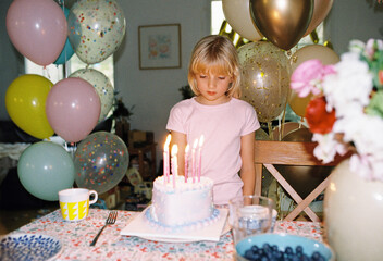 A girl with a birthday cake at home