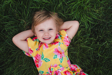Little Girl Laying in Field of Grass