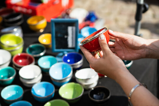 Woman hand holding bright vintage dishes at flea market
