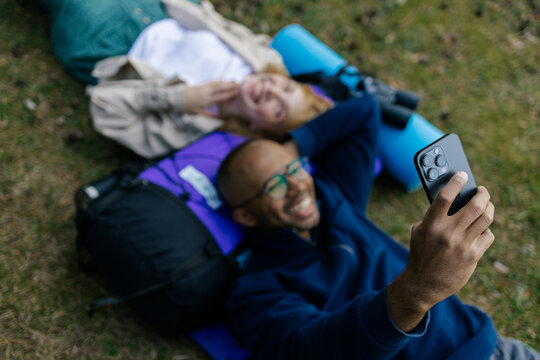 A man and a woman use a mobile phone on a hike