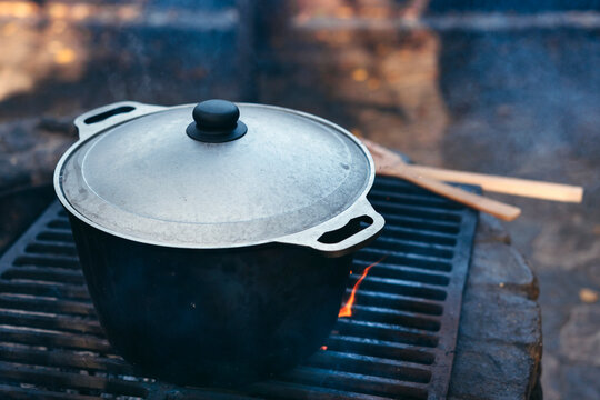 Cooking food in cauldron on open fire.