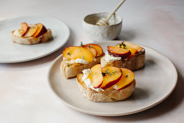 A light meal of plums, cream cheese and honey on toast.