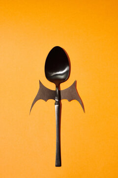 black spoon decorated with bat wings
