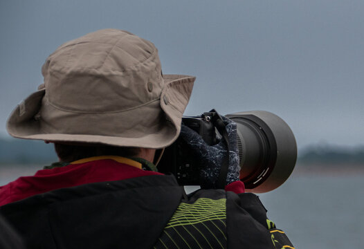 Fototapeta Fotógrafo en acción en el mar con un teleobjetivo y un gorro
