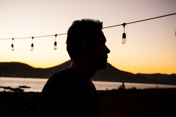 Silhouette of Man at Sunset with String Lights