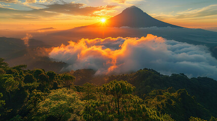 Breathtaking sunrise over a misty mountain landscape with lush greenery in the foreground. - obrazy, fototapety, plakaty