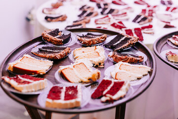 Slices of vanilla and red velvet cake on a tray served at a party