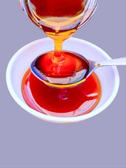 Bee honey rawhoney pouring on spoon and a bowl sweet food natural sweetener ingredient floral nectar extracted from bees hive miel,  beemel, honig, miele, closeup view image stock photo