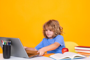 School child using laptop computer. School and kids. Cute blonde child with a book learning. Knowledge day.