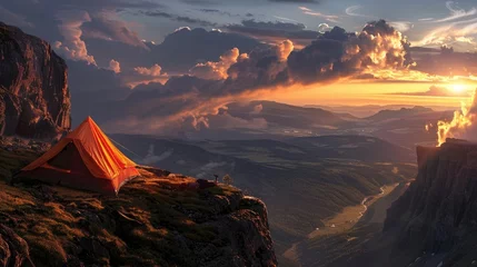 Fotobehang An orange tent at the brink of a mountain cliff overlooking a large, gloomy valley below, shining under a magnificent sunset sky full of rolling clouds and the last of the sun's rays.  © Muhammad