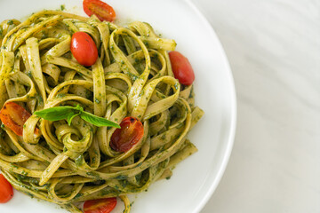 fettuccine spaghetti pasta with pesto sauce and tomatoes