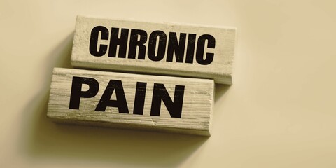 chronic pain word made with building blocks. Wooden Blocks with the text: chronic pain. The text is written in black letters