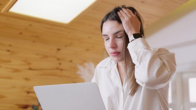 Tired, exhausted woman working on computer laptop, problems with job, feeling depressed, laziness in living room