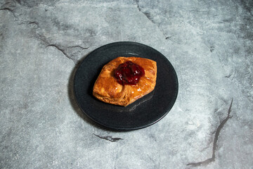 Strawberry Danish puff pastry filled with sweet cheese served in plate isolated on background top...