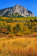 Rugged Marcellina Mountain surrounded by fall colors and yellow grass as seen from the Kebler Pass...