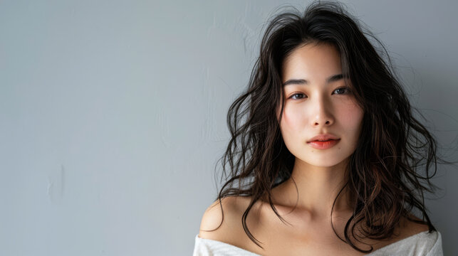 Beauty portrait of a natural young Japanese woman with a soft grey copy space background