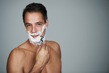 Man, portrait and shaving cream with razor for skincare treatment with hair removal, studio or grey...