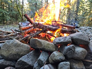 Flames from wood fire in the campground in a fire pit made from rocks in the forests of Washington State