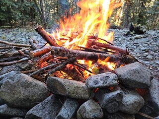 Flames from wood fire in the campground in a fire pit made from rocks in the forests of Washington State