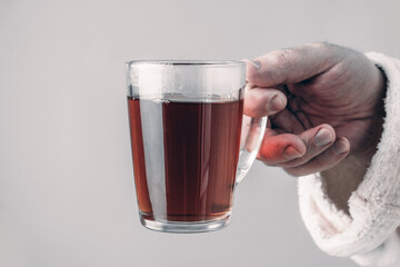 An adult man holds the cup. Man spends time at home, relaxing, and feeling carefree, enjoying morning tea.